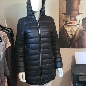 Black long puffer coat with gold zippers, pockets